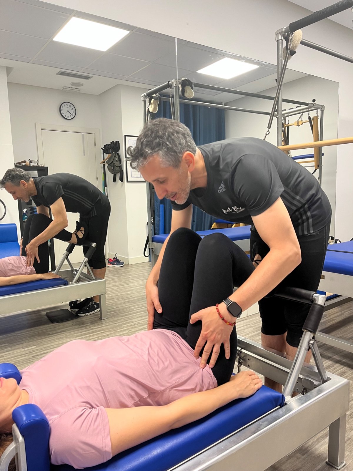 Carlos Castillo corrigiendo a una embarazada durante una clase de Pilates en Reformer en Madrid.