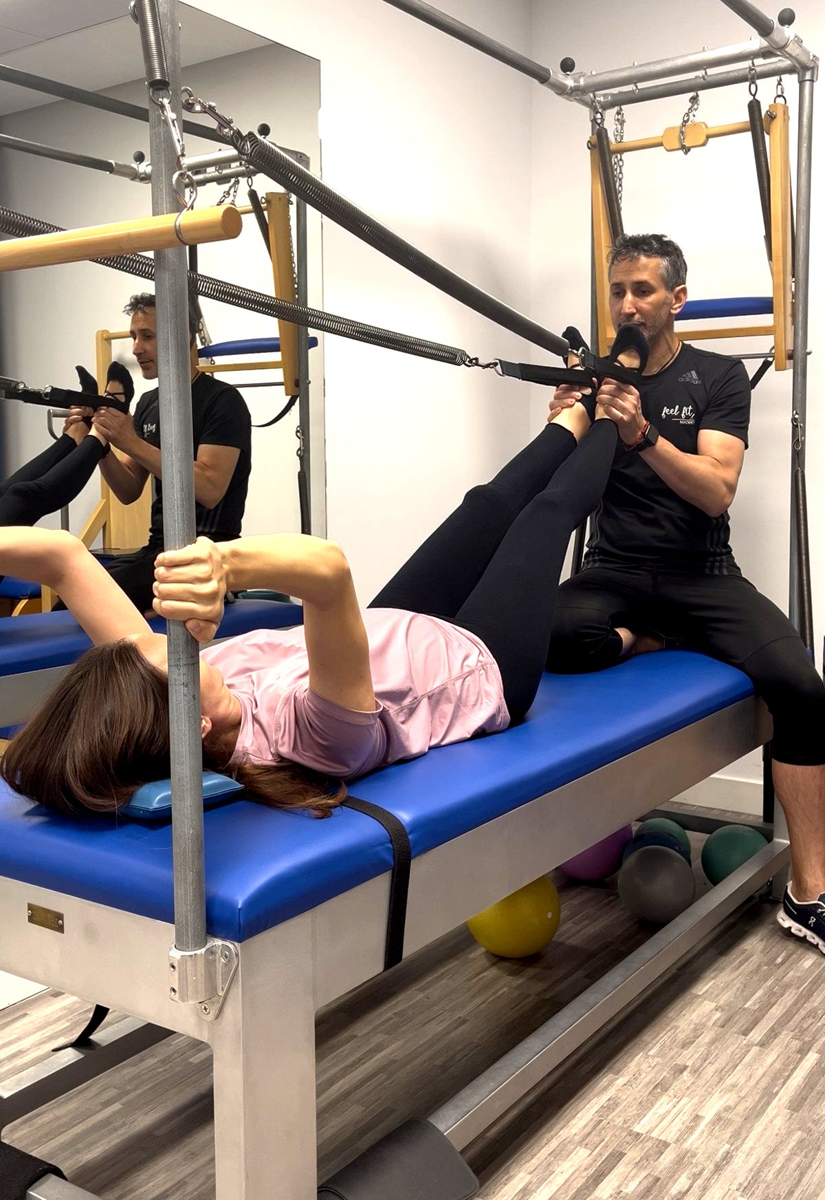 Carlos Castillo guiando ejercicios con aparatos de Pilates a una embarazada en su estudio en Madrid.