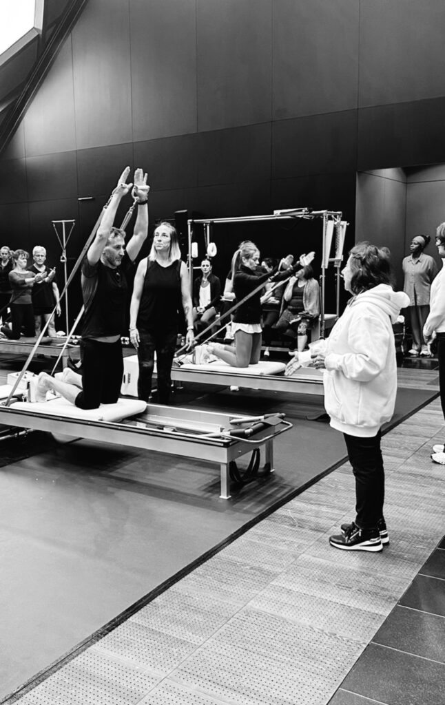 Sari Mejía guiando a Carlos Castillo en un ejercicio avanzado de Pilates durante un CPE de Romana’s Pilates Internacional.