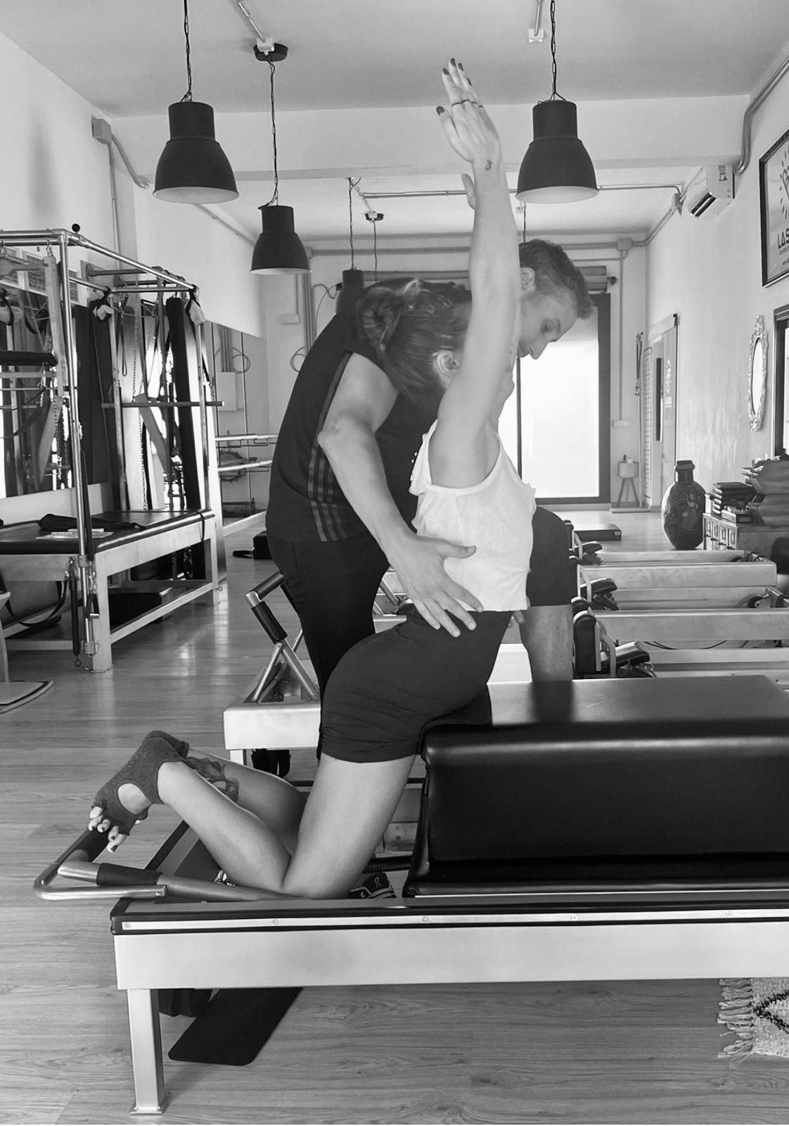 Profesor corrigiendo un ejercicio avanzado en Reformer en Feel Fit Pilates Madrid, estudio oficial Romana’s Pilates en el Barrio de Salamanca.