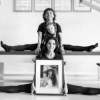Sari Mejía Santo, Daria Pace y su hija sosteniendo un retrato de Romana Kryzanowska, símbolo del legado de Romana’s Pilates International y del auténtico método Pilates.